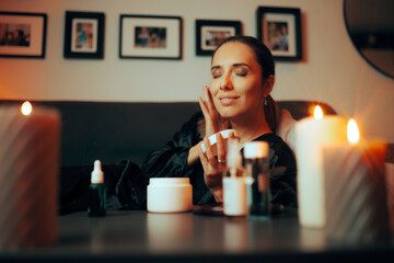 Woman Doing her Skin Care Routine in the Evening at Candlelight. Adult person using moisturizer on her face before sleep
