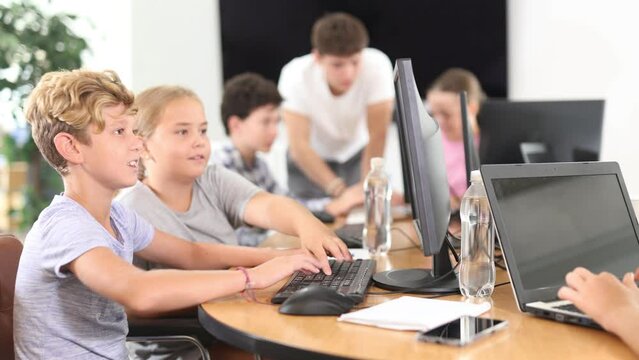 Computer science lesson in a school computer class - a girl and a boy solve problems on the computer together. High quality 4k footage