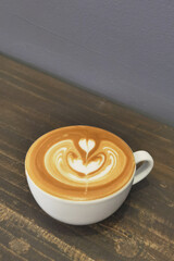 a cup of latte art coffee on wooden background            