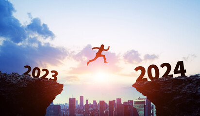 Silhouette of businessman jumping from 2023 to 2024. 2024 New Year concept. New year's card 2024....