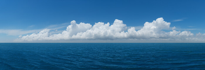 White cumulus clouds above blue Ocean