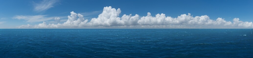 White cumulus clouds above blue Ocean
