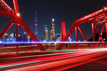 a famous bridge of The Bund in Shanghai at night and beautiful light trail at highway