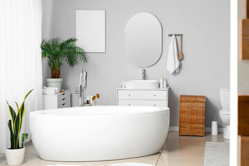 Interior of light bathroom with bathtub and toilet bowl