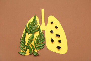 Paper lungs with leaves and tumors on brown background. Lung cancer concept