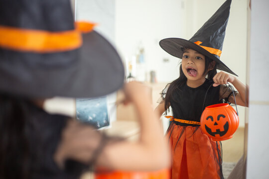 Happy Asian child girl in a witch costume to Halloween. trick or treat. Kids trick or treating.