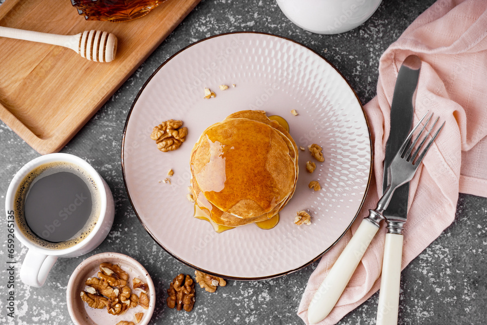Wall mural tasty pancakes with nuts, maple syrup and cup of coffee on grey background