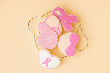 Pink cookies with ribbons and word HOPE on beige background. Breast cancer awareness concept