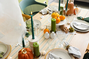Festive table setting with burning candles and pumpkins for Halloween party