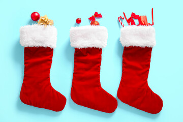 Christmas socks with bows, balls and gift boxes on blue background