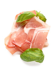 Slices of tasty prosciutto with basil on white background