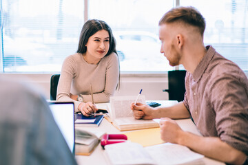 Fototapeta premium Female student explaining information to classmate
