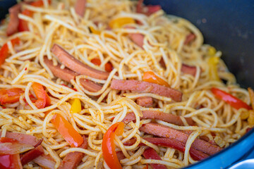 Closeup bowl of spicy spaghetti with sausages