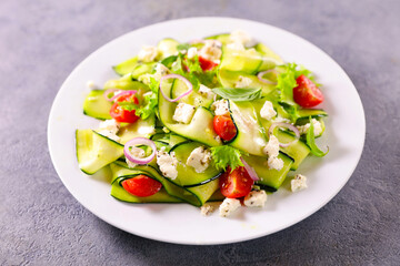 Salad of zucchini slices with spices, tomatoes and feta cheese- Vegan food, healthy food