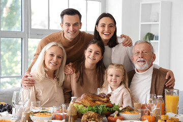 Happy family having dinner at festive table on Thanksgiving Day