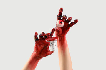 Bloodstained zombie hands holding eyeball and mushroom on white background. Halloween celebration