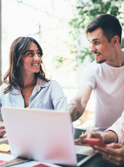 Business partners using gadgets in work and talking to each other