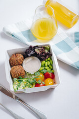 bowl in Chinese style.meatballs with beans, herbs, cherry tomatoes and sauce in a container top view