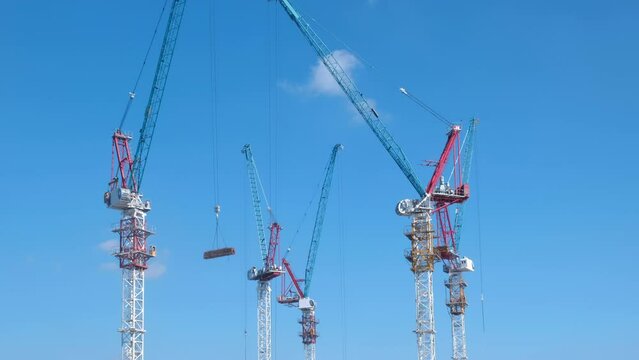 Aerial view of a large construction site with cranes at dusk. Timelapse.