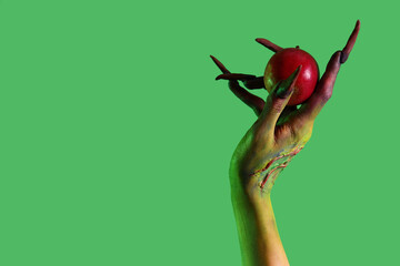 Witch with apple on green background. Halloween celebration