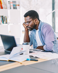Obraz premium Black man working with laptop in office