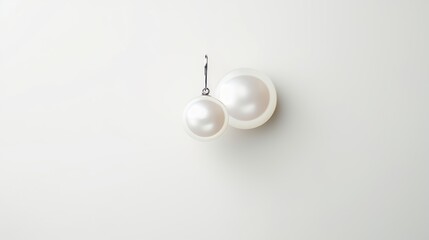 a pair of beautiful and classy pearl earrings made of two large white pearls attached to a thin silver wire. The pearls have a smooth and shiny surface that reflects light. The image has a high