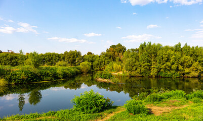 Landscape with river, trees and blue sky