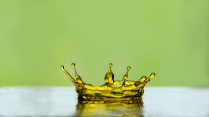 Water drop. Water drop crown blur. Slightly blurred golden yellow  water droplets. natural water drop concept and green background.