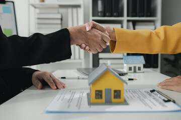 Sales staff discuss home details with customers before agreeing to sign a sales contract, buying...