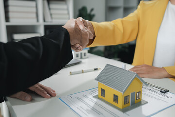 Sales staff discuss home details with customers before agreeing to sign a sales contract, buying...