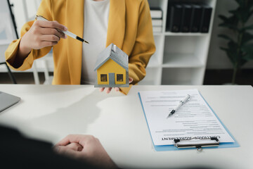 Sales staff discuss home details with customers before agreeing to sign a sales contract, buying...