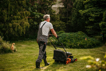 Experienced senior gardener keeps his lawn immaculate while wearing a classic suit