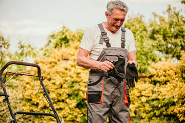 Elderly gentleman meticulously trims his backyard garden in a dapper work suit, showcasing his...