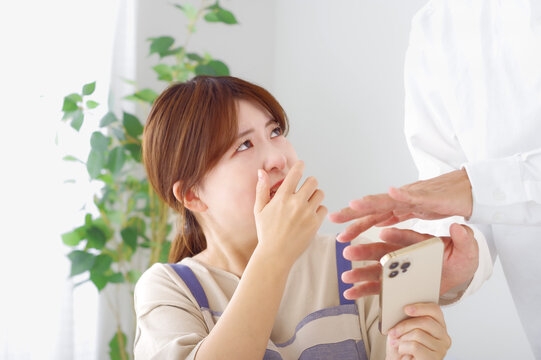 男性のスマホを見て複雑な表情をする女性