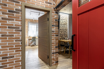 Apartment interior with sliding red door and clay red brick wall decoration