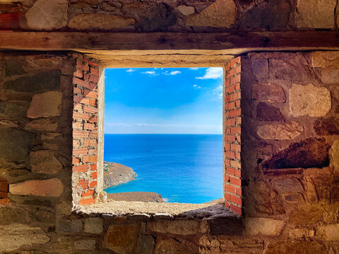 Open Framed Window in a wall of stone and brick in a construction site with an idyllic view of the Mediterranean Sea.  Stock Image.