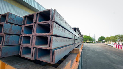 The steel channels are tied up in the warehouse before shipping. Construction steel is shaped like the letter U.