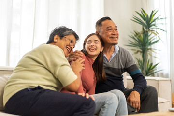 Obraz premium Portrait enjoy happy smiling love asian family.Senior mature father hug with elderly mother and young adult woman play laughing and having fun together at home.insurance concept