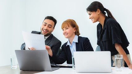 Three smiling diverse business colleagues having business strategy meeting.