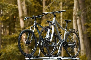 Fototapeta premium Outdoor Adventure Awaits. Family Car with Bicycles Mounted on Roof Rack. A vehicle with top mounted bikes.