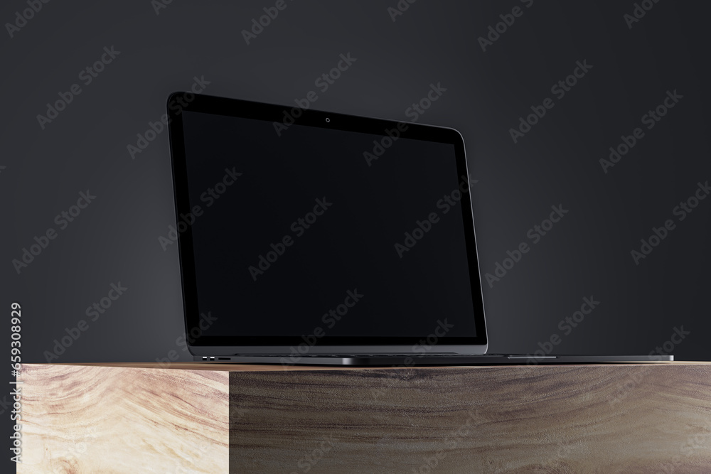 Poster close up of blank laptop monitor on wooden surface and gray wall background. product presentation an