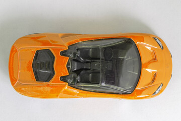 Topview of orange toy model supercar on a white background