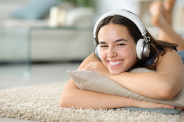 Happy woman looks at you wearing headphone