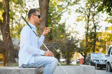 Blinded man waiting for bus at a bus station