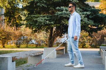 Young blinded man using phone and sending voice message