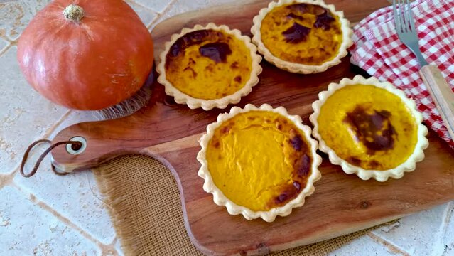 plusieurs tartelettes au potiron sur une planche &agrave; d&eacute;couper