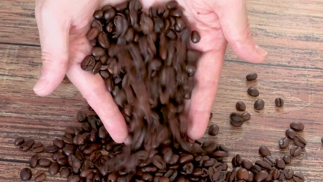 mains versant des grains de caf&eacute; sur une table