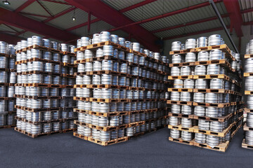 depot of stainless steel beer kegs to be distributed by delivery workers in city breweries