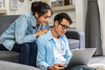 Young asian couple relaxing using laptop computer work and video conference meeting online chat.Creative business couple planning strategy analysis and brainstorm at home