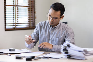 Serious and focused financier accountant on paper work inside office, mature business asian man...